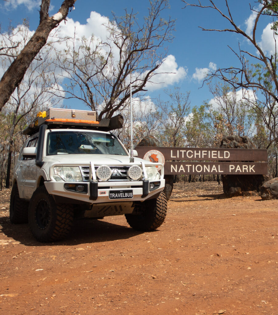White 4wd car next to Litchfield National Park sign on a sunny day, Litchy