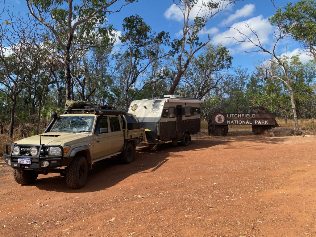 4wd car parked bext to litchfield national park sign on a sunny day. litchy