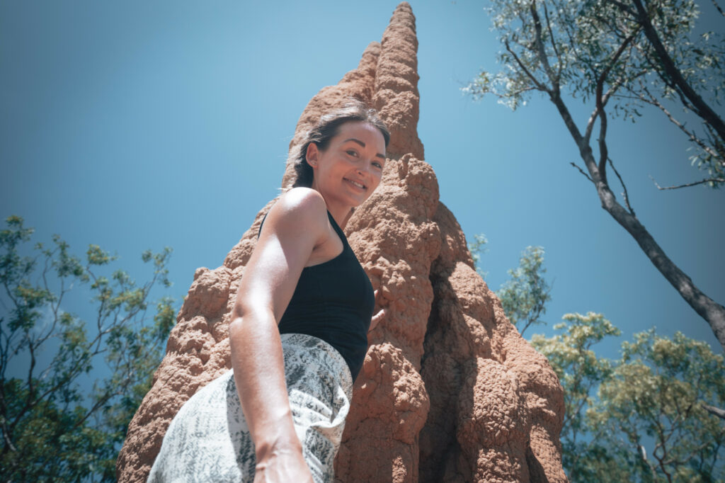 Woman looking down, net to magnetic termite mound in litchfield national park, Litchy