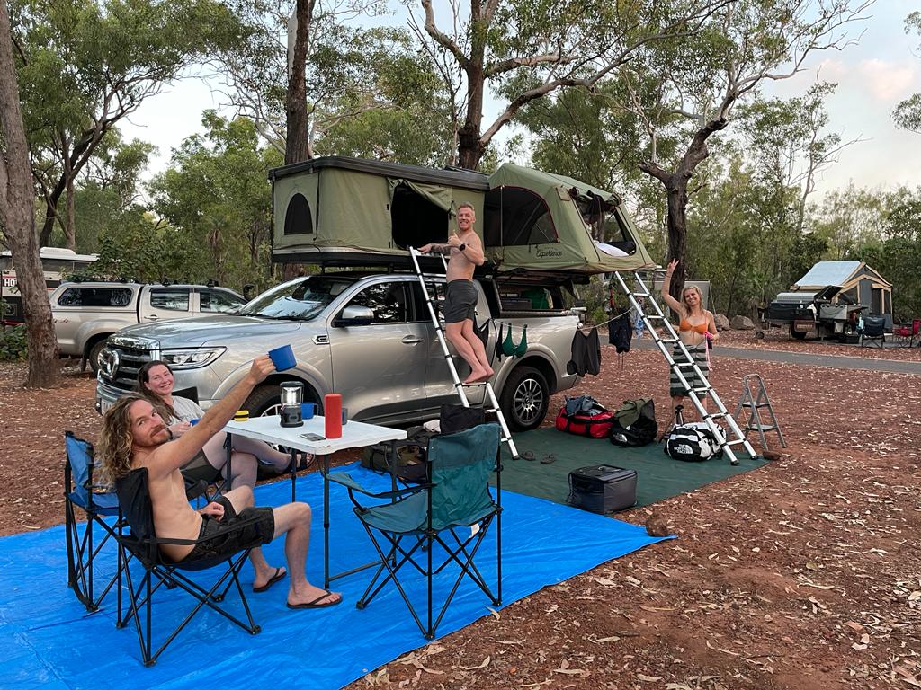 Four people camping on amobile tent on top of a 4wd vehicle in Litchfield National Park, Litchy